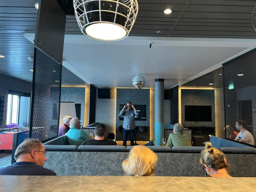 Workshop-Szene in modernem Veranstaltungsraum mit Moderator und sitzenden Teilnehmern