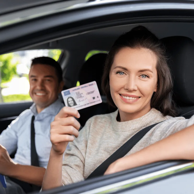 Businessplan Fahrschule – Vorlage mit Excel-Finanzplan 3 Junge Frau in Auto zeigt Führerschein-Dokument, Fahrlehrer im Hintergrund