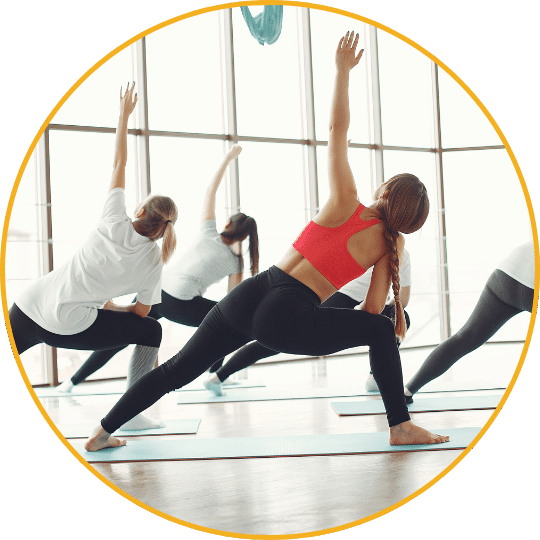 Yoga- und Pilates-Klasse mit Frauen in verschiedenen Positionen vor großem Fenster