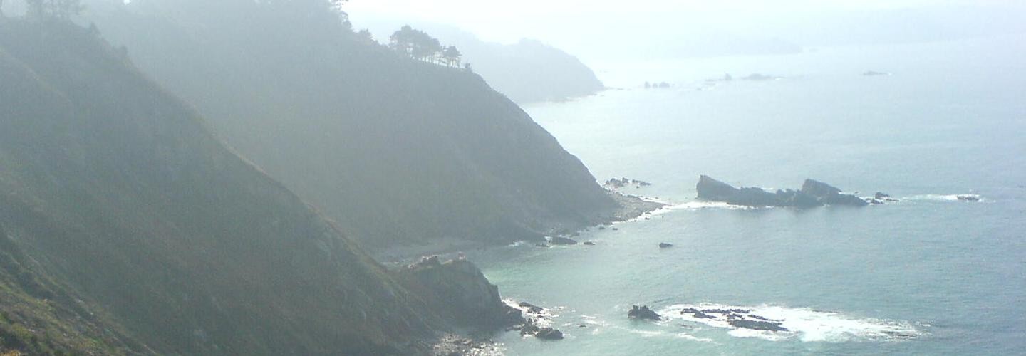 Küstenlandschaft mit Klippen, Meer und Nebelschleier am Camino del Norte in Nordspanien
