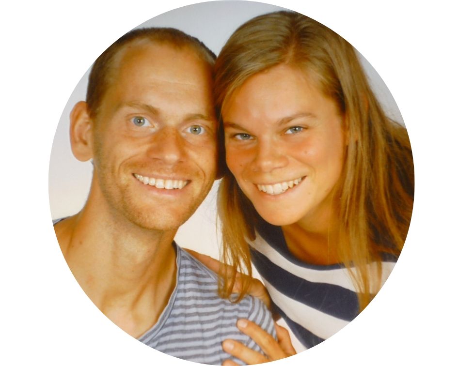 Portrait von Anna und Nico Wirth, Paar lächelnd vor grauem Hintergrund