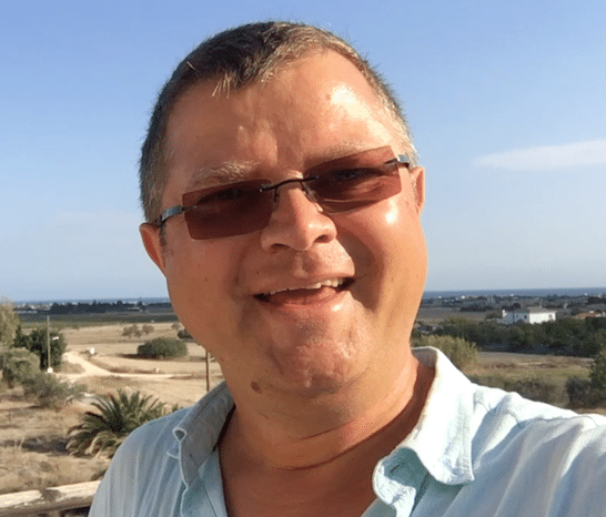 Portrait von Hecky, Mann mit Sonnenbrille vor Landschaftshintergrund
