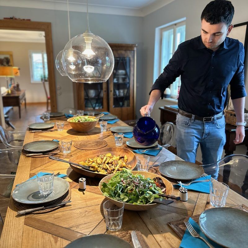 CEO Growth Mentoring – Coaching zur Unternehmensskalierung 25 Mann bereitet Tisch beim CEO Growth Mentoring Dinner vor mit Salatschüsseln
