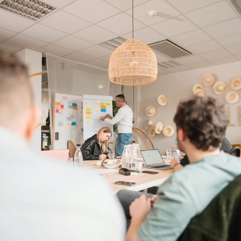 CEO Growth Mentoring – Coaching zur Unternehmensskalierung 13 CEO Growth Mentoring Workshop mit Teilnehmern am Tisch unter Rattan-Pendelleuchte