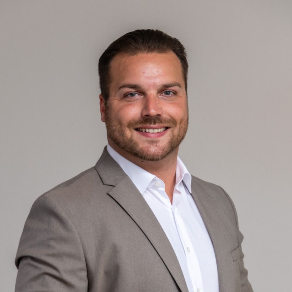 CEO Growth Mentoring – Coaching zur Unternehmensskalierung 29 Porträt von Philipp Bundschu in grauem Sakko und weißem Hemd vor neutralem Hintergrund