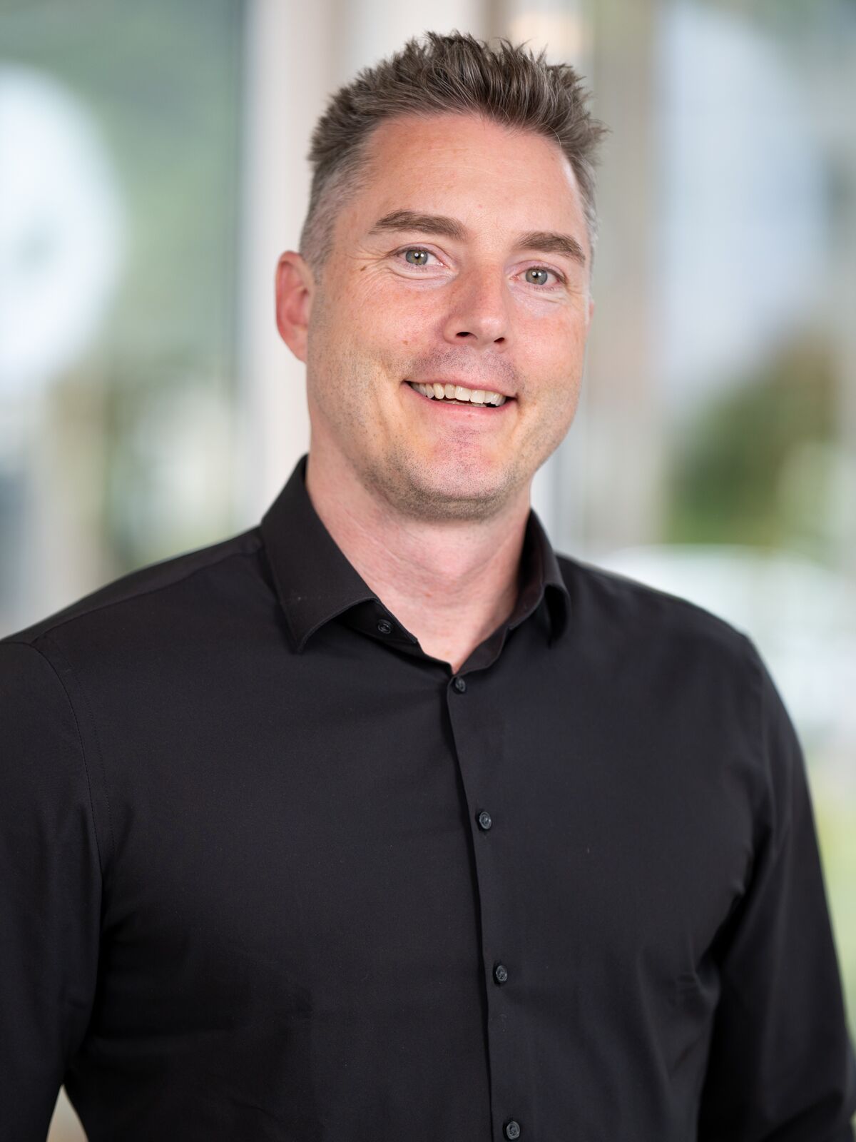 CEO Growth Mentoring – Coaching zur Unternehmensskalierung 15 Porträt von Beat Wyss, Scale-up Coach, schwarzes Hemd vor verschwommenem Hintergrund