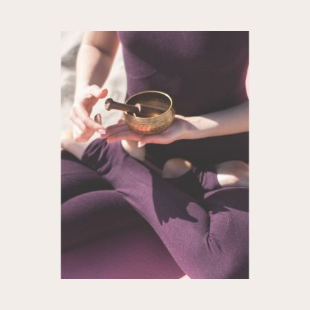 Hände halten Klangschale während Chakra-Yoga-Sitzung