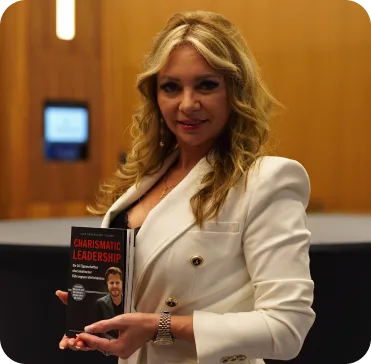 Charismatic Leadership – Praxisbuch über Führung 4 Frau Svetlana L. im weißen Blazer hält das Charismatic Leadership-Buch