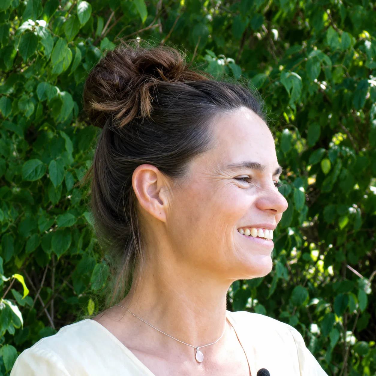 Chlorophyll-Bundle Online – Videokurs zu grüner Ernährung 27 Sabine Kleinhainz, Frau mit dunklen Haaren, Seitenprofil vor grünem Efeu