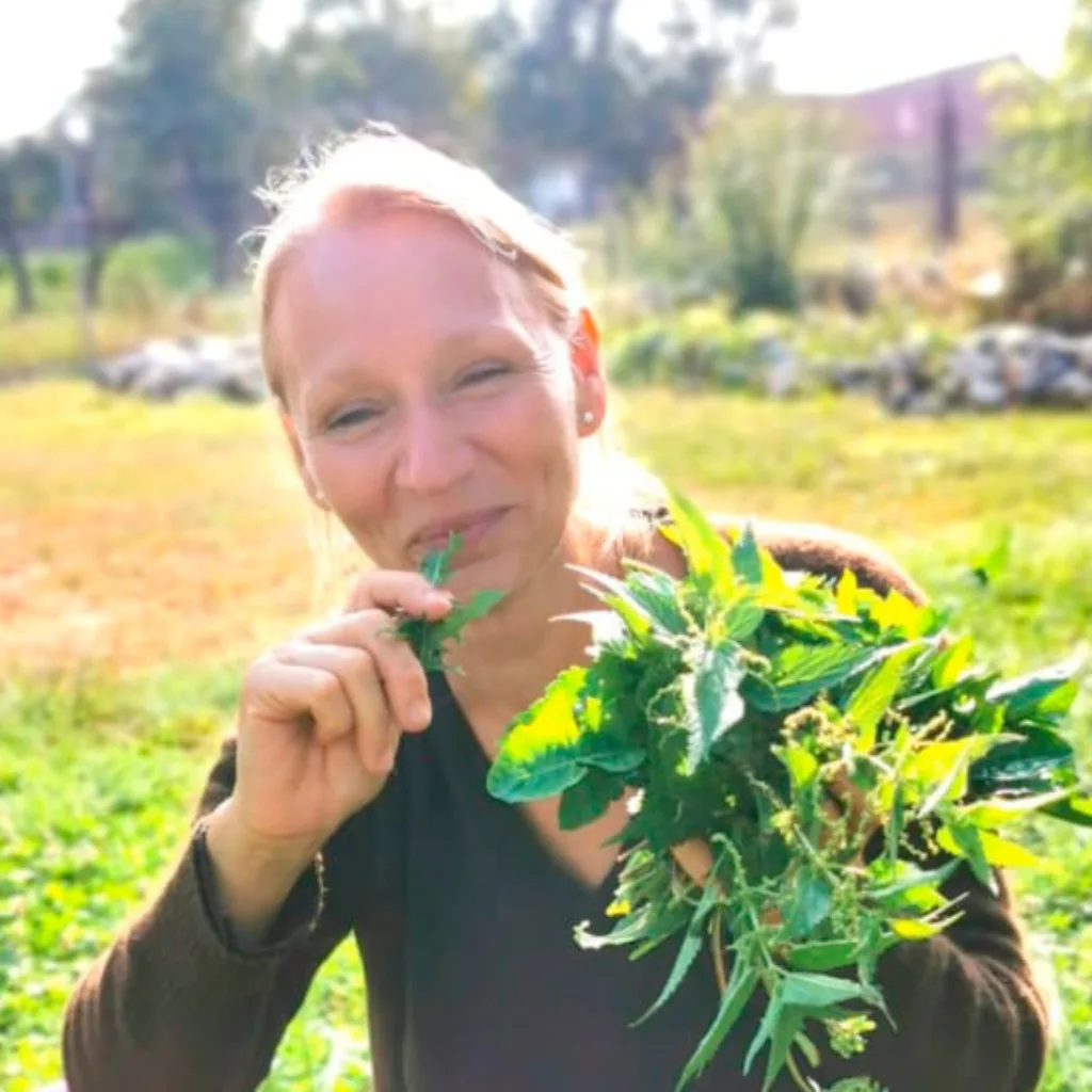 Chlorophyll-Bundle Online – Videokurs zu grüner Ernährung 19 Astrid Drottleff, Frau hält Wildkräuter, lächelt im Freien