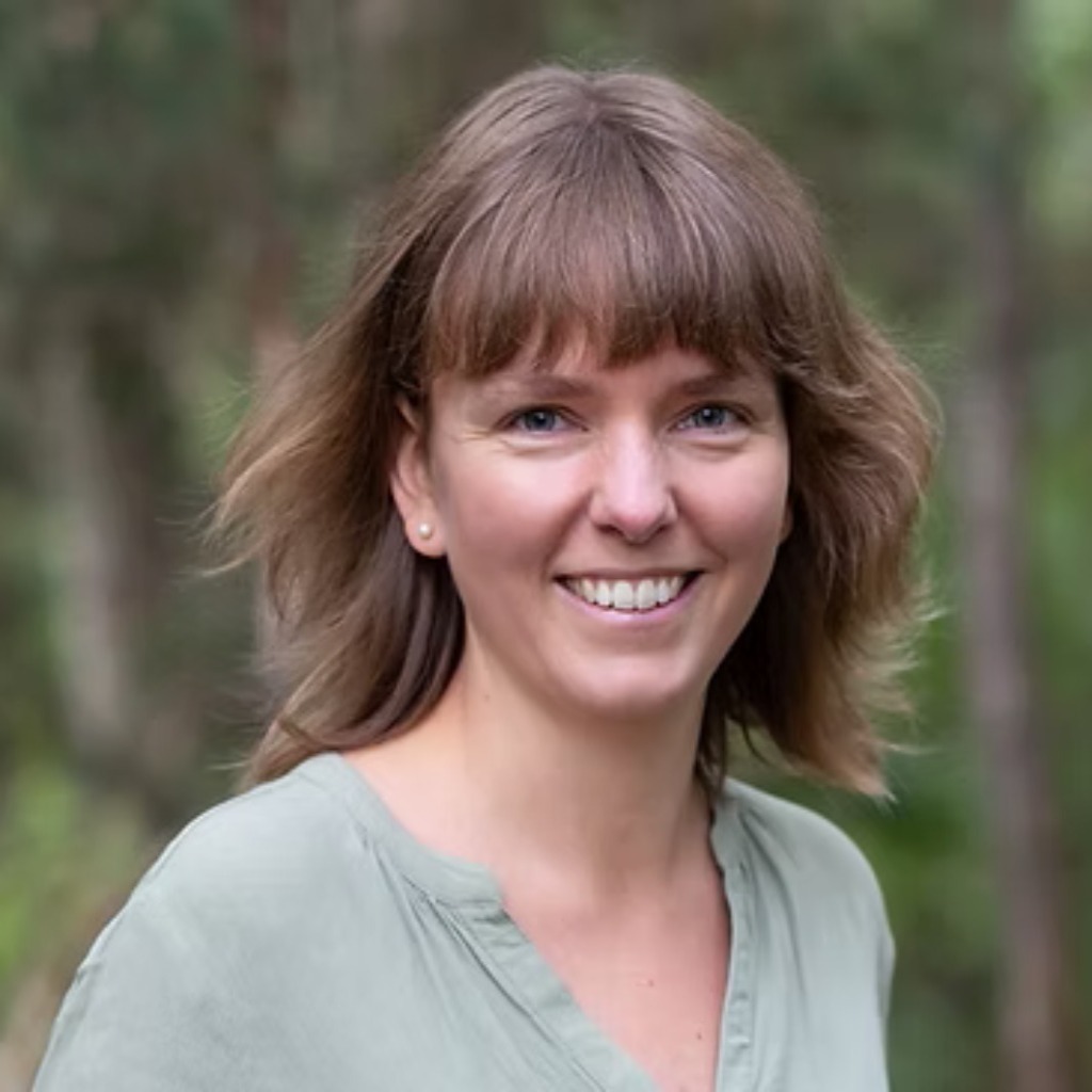 Chlorophyllkongress – Videokongress über Blattgrün von Maria Kageaki 19 Jenny Zuber, Frau mit braunem Haar und Pony, vor unscharfem grünem Hintergrund
