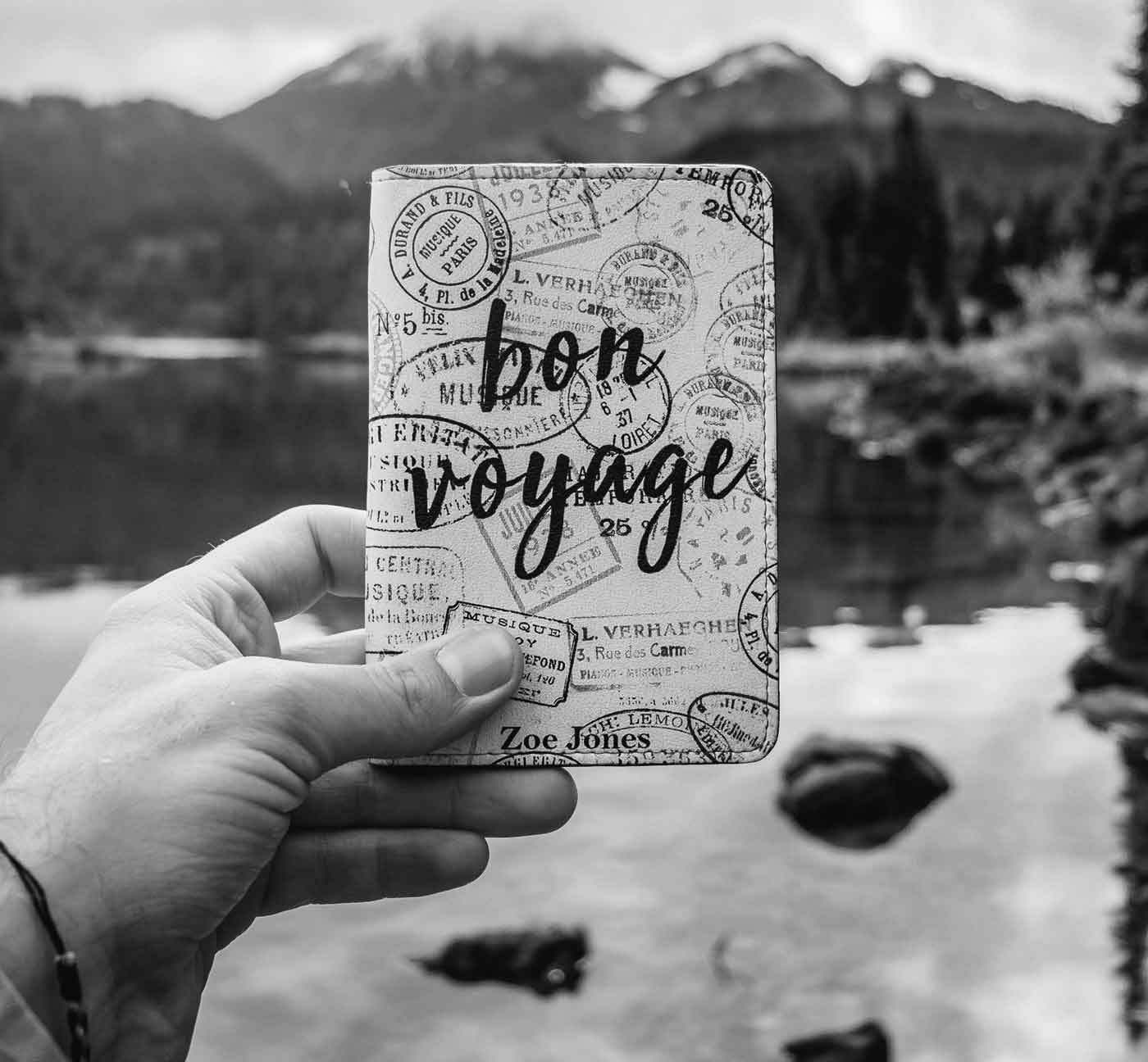 Schwarzweiß-Foto eines Reisepasses mit Stempeln und Handschrift 'Bon Voyage'