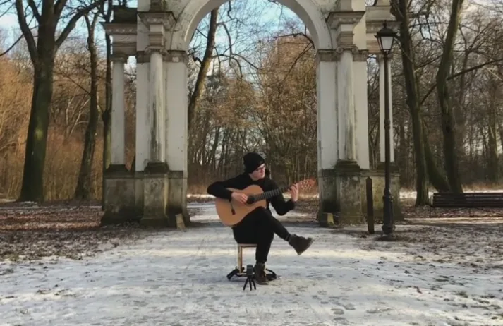Person spielt Gitarre unter klassischen Arkaden im Park, Kundenstimme