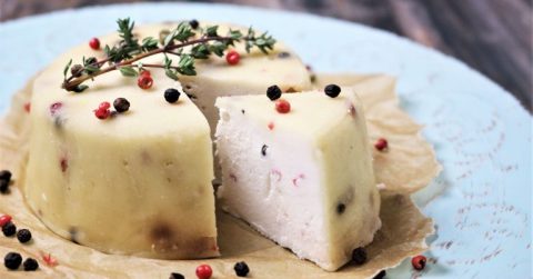 Cremiger Macadamia-Pfeffer Brie Käse mit Beeren und Rosmarin auf Teller