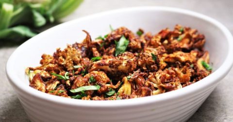 Knusprige Gemüsecrisps in weißer Schüssel, garniert mit Frühlingszwiebeln