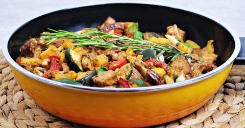 Ratatouille mit mediterranen Kräutern in gelber Pfanne mit Gemüse