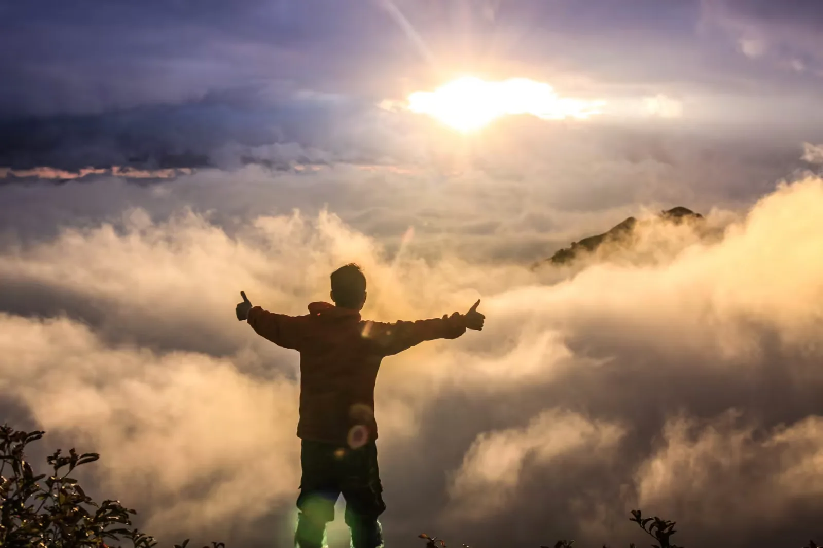Creation Master Studio – Videokurs für mehr Projektfokus 3 Person mit ausgestreckten Armen in Wolken bei Sonnenaufgang, Erfolgsmotiv