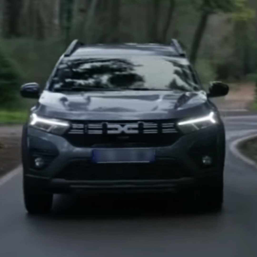 Dacia Jogger Kompaktvan von vorne auf einer Landstraße mit Wald im Hintergrund