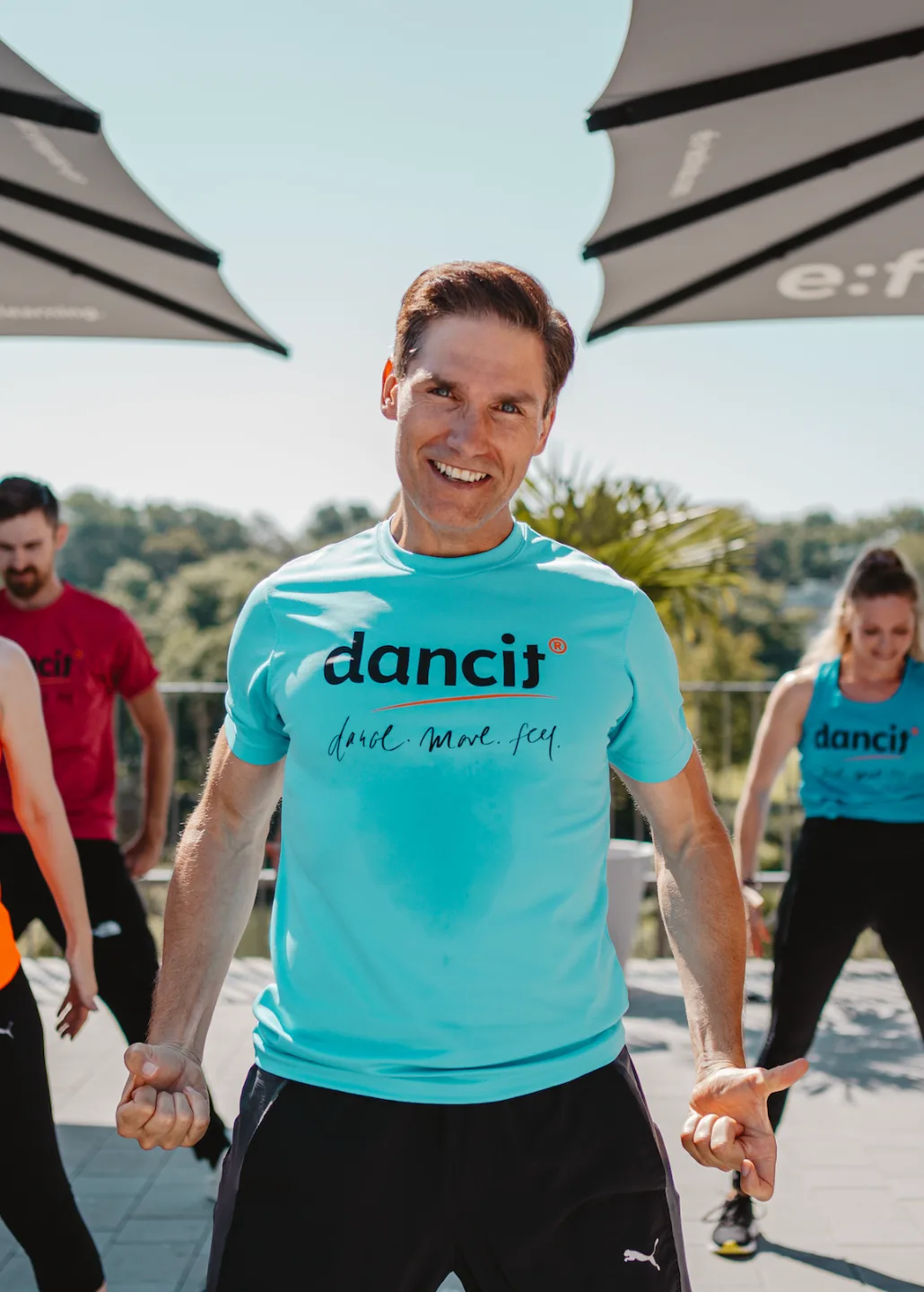 Christian Polanc in türkisem dancit Shirt auf Terrasse