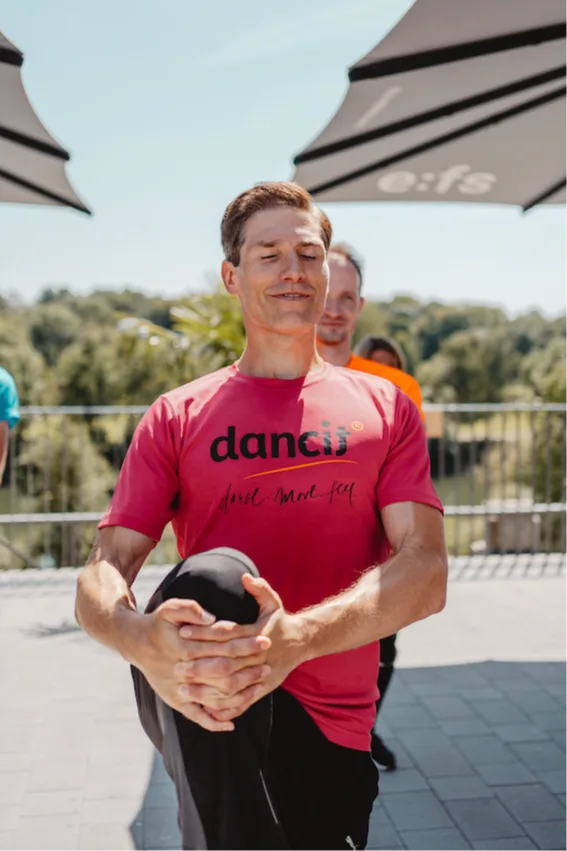 Christian Polanc in rosa dancit Shirt mit Medizinball