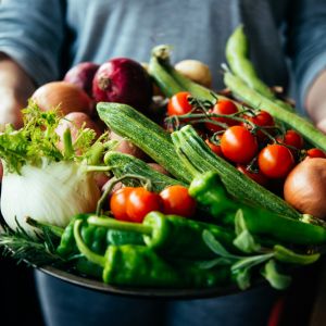 Überfluss an frischem Gemüse in Händen, Salat und Tomaten
