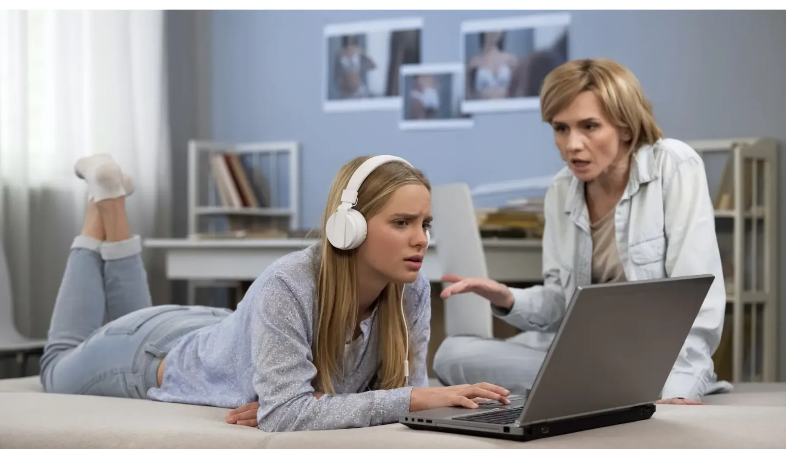 Mutter spricht mit Tochter die Kopfhörer trägt und am Laptop sitzt