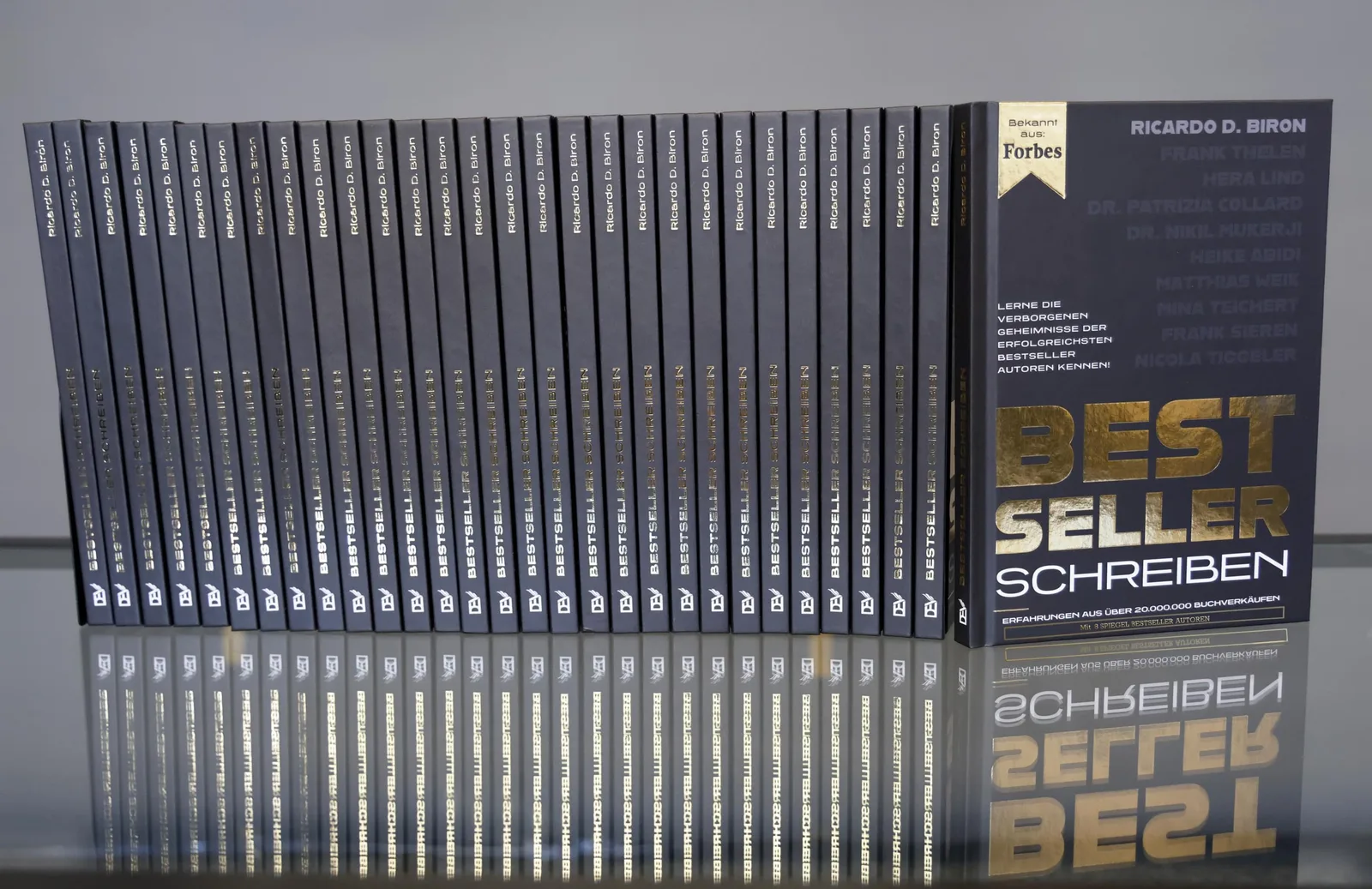 Stapel von 30+ dunkelblauen Bestseller schreiben Büchern nebeneinander angeordnet mit Cover im Vordergrund