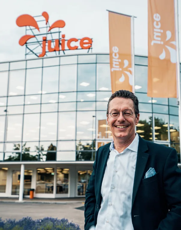 Porträt Christoph Erni vor Juice-Gebäude mit Unternehmenslogo