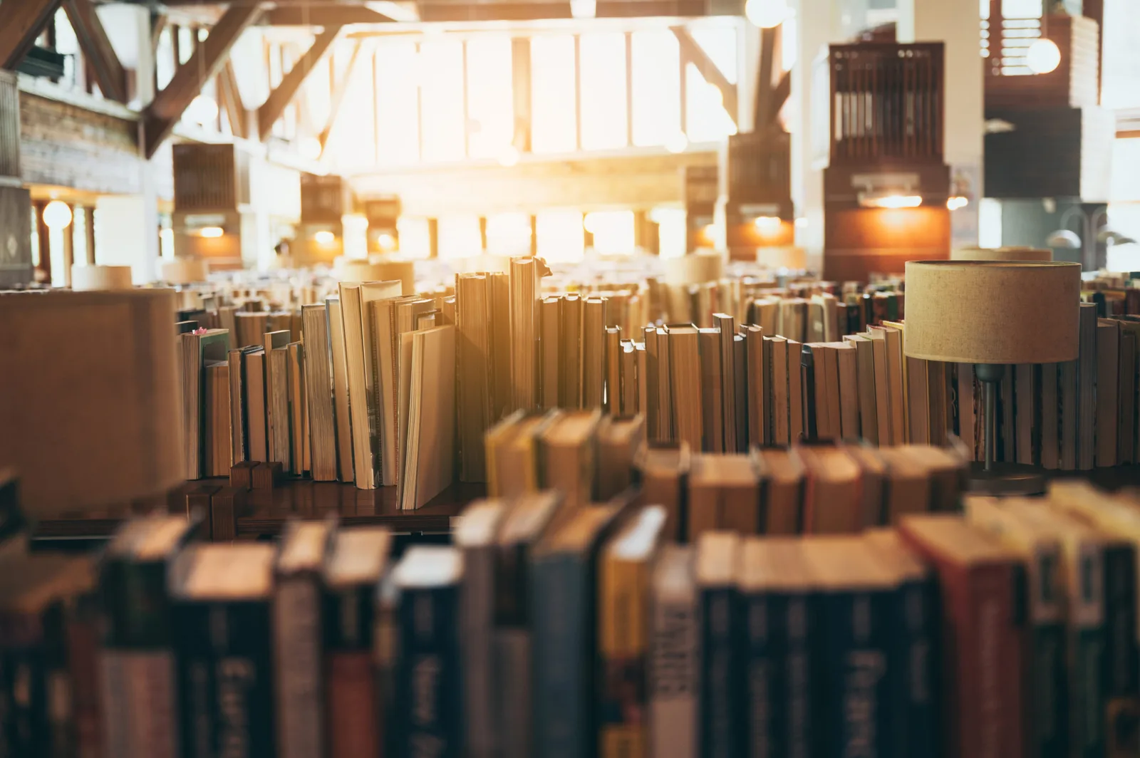 Bibliothek mit unscharfen Buchständern in warmem Licht