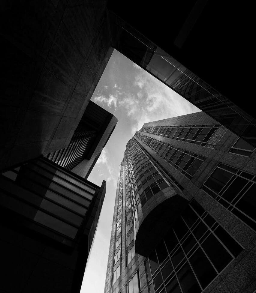 Decluttering Workshop – Coaching zur Neuorientierung von Petra Ecker 3 Schwarz-Weiß-Aufnahme von Hochhäusern von unten fotografiert gegen Himmel