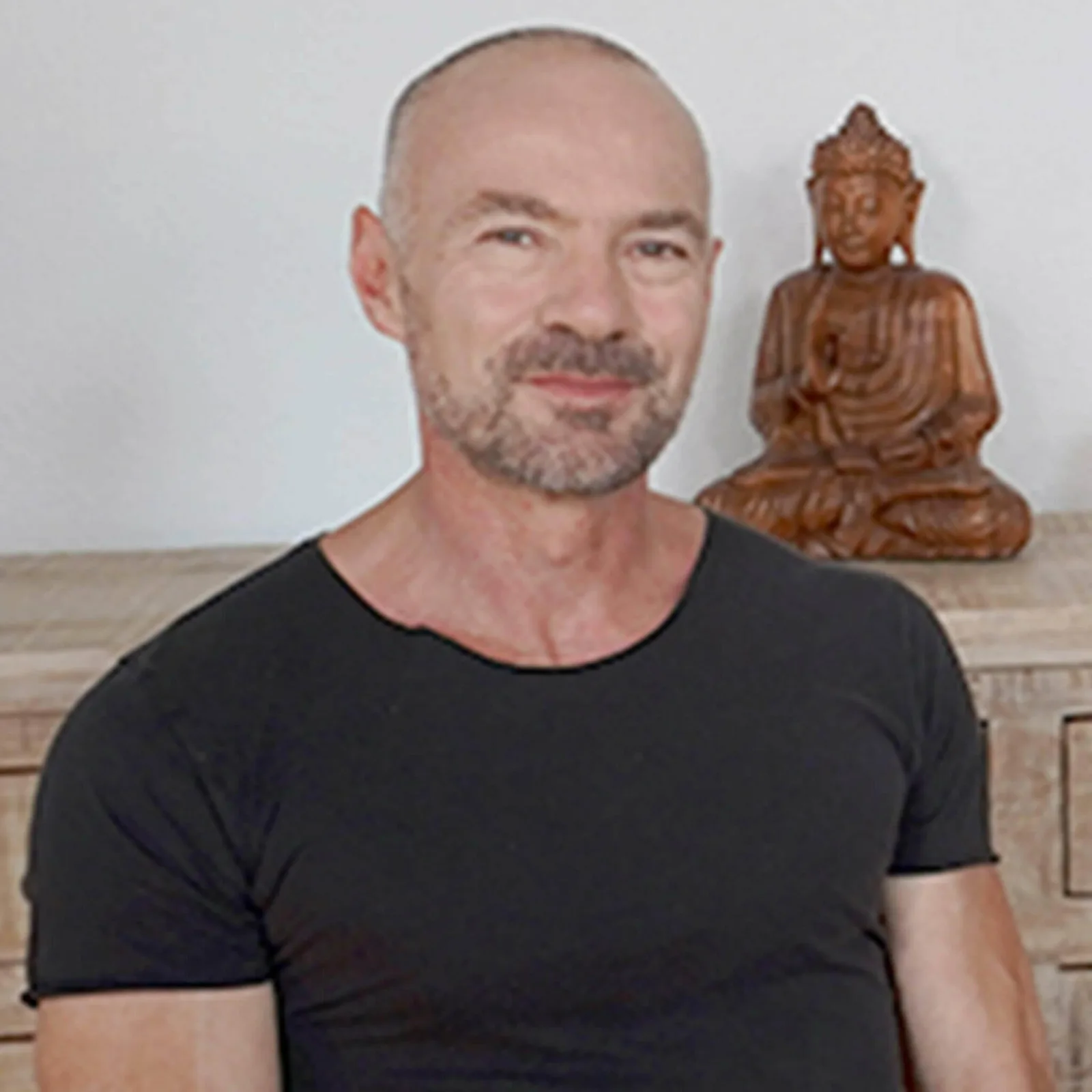 Porträt von Karl Seeger (ehemals Hartner) mit Buddha-Statue im Hintergrund