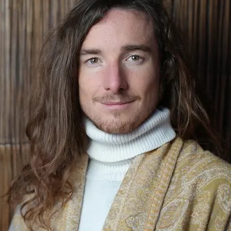Robin Kaiser, Sprecher, Portrait mit langen Haaren und Rollkragenpullover