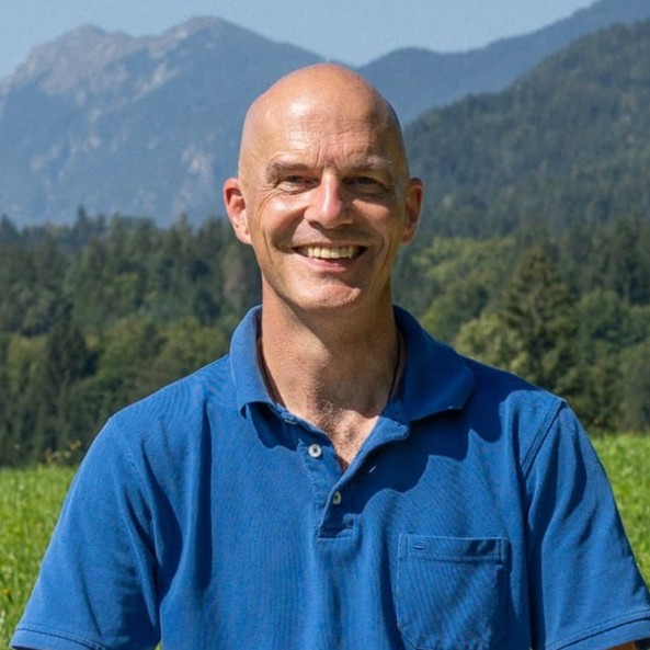 Christian Opitz, Sprecher, Portrait vor Berglandschaft mit blauem Poloshirt