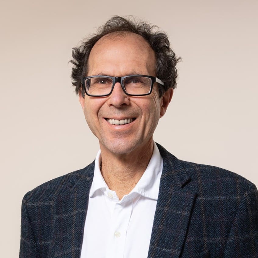 Dr. John Switzer, Sprecher, Portrait mit Brille und Blazer