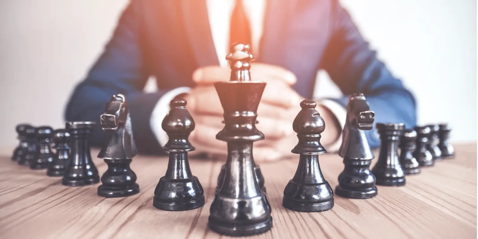 Geschätsmann bewegt Schachfigur, umgeben von Schachfiguren, Strategie und Business