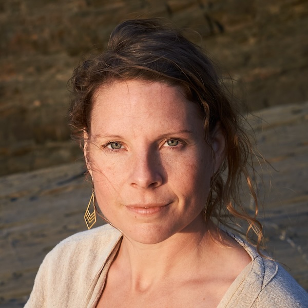 Lisa Henrike Porträt, dunkles Haar, goldene Ohrringe, natürlicher Hintergrund mit Stein