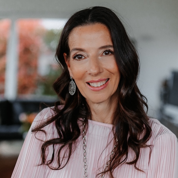 Christine Schäfle, dunkelhaarige Frau in rosa Oberteil vor Bürokulisse