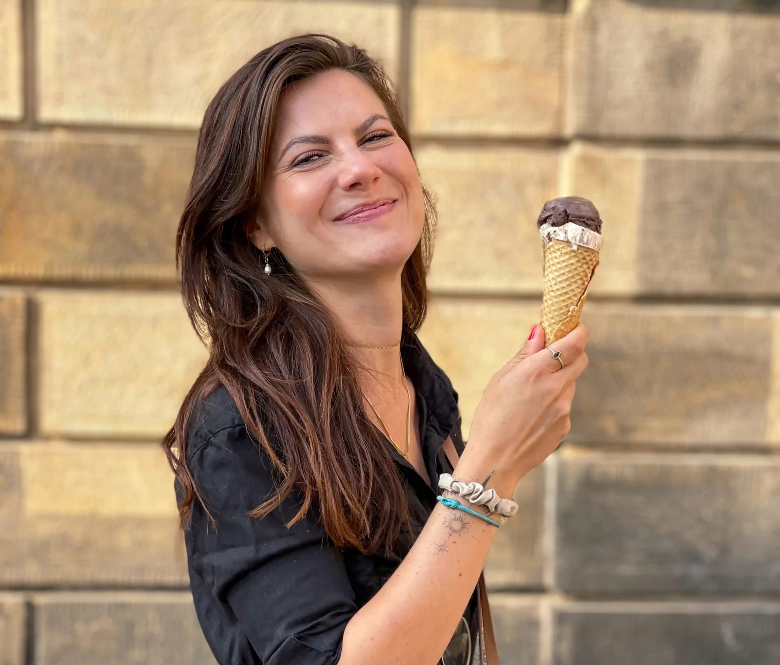 Dein Zyklus Guide – E-Book zur Periodenernährung von Jenny Tröger 3 Jenny Tröger mit Eiscreme vor Steinwand, fröhliches Portrait