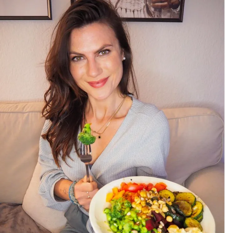Dein Zyklus Guide – E-Book zur Periodenernährung von Jenny Tröger 5 Frau mit Gabel und Salatschüssel auf Couch, gesunde Ernährung