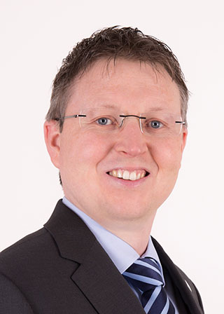 Porträtfoto von Christoph Beutekamp mit Brille und blauer Krawatte