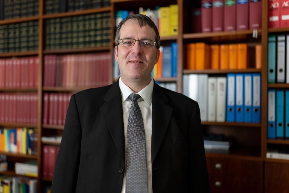 Andreas Hebentanz, Steuerberater, vor Bücherregal mit fachlicher Literatur