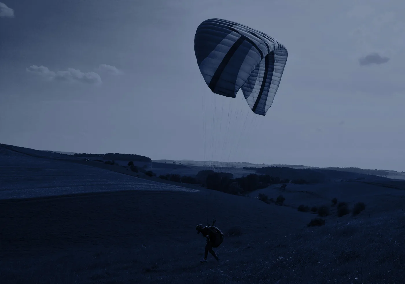 Offener Fallschirm im Himmel über Landschaft beim Landen