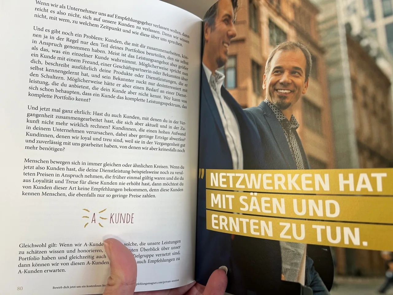 Aufgeschlagenes Buch mit Text und Foto von zwei lächelnden Männern mit goldenem Banner 'Netzwerken mit Saen und Ernten zu tun