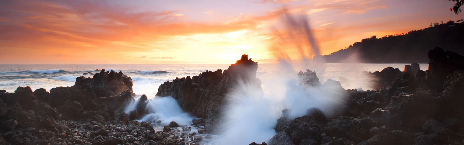 Hawaii Küstenszenerie – Felsküste mit donnernden Wellen bei goldenem Sonnenuntergang