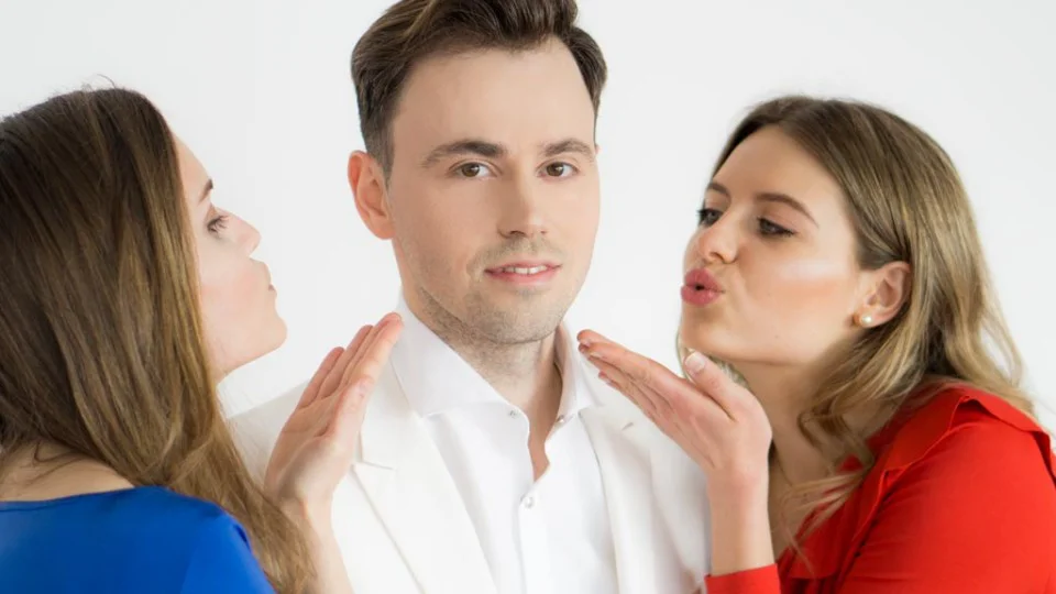 Hero-Image zum Flirtkurs mit drei Personen - Mann in der Mitte wird von zwei Frauen flirtend angesprochen