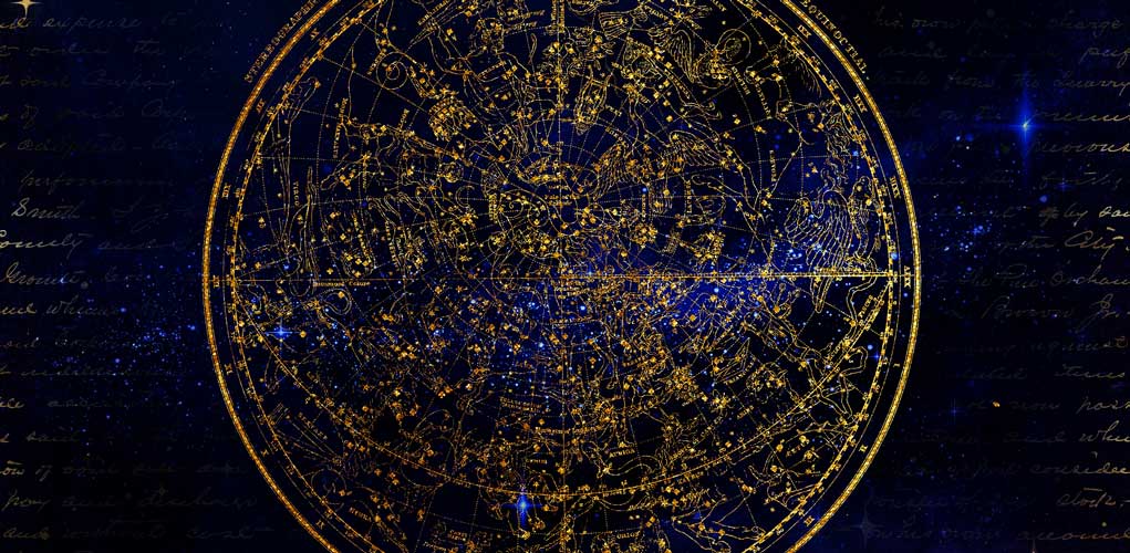 Goldenes Astrologie-Horoskop-Rad mit Sternenkarte auf dunklem Hintergrund