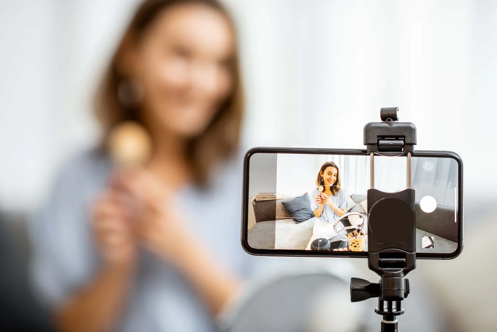Frau nimmt Video auf Smartphone mit Stativ, Selfie-Setup