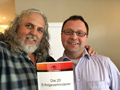Mann mit Brille neben Ernst Crameri, beide halten das Buch Die 20 Erfolgsverhinderer