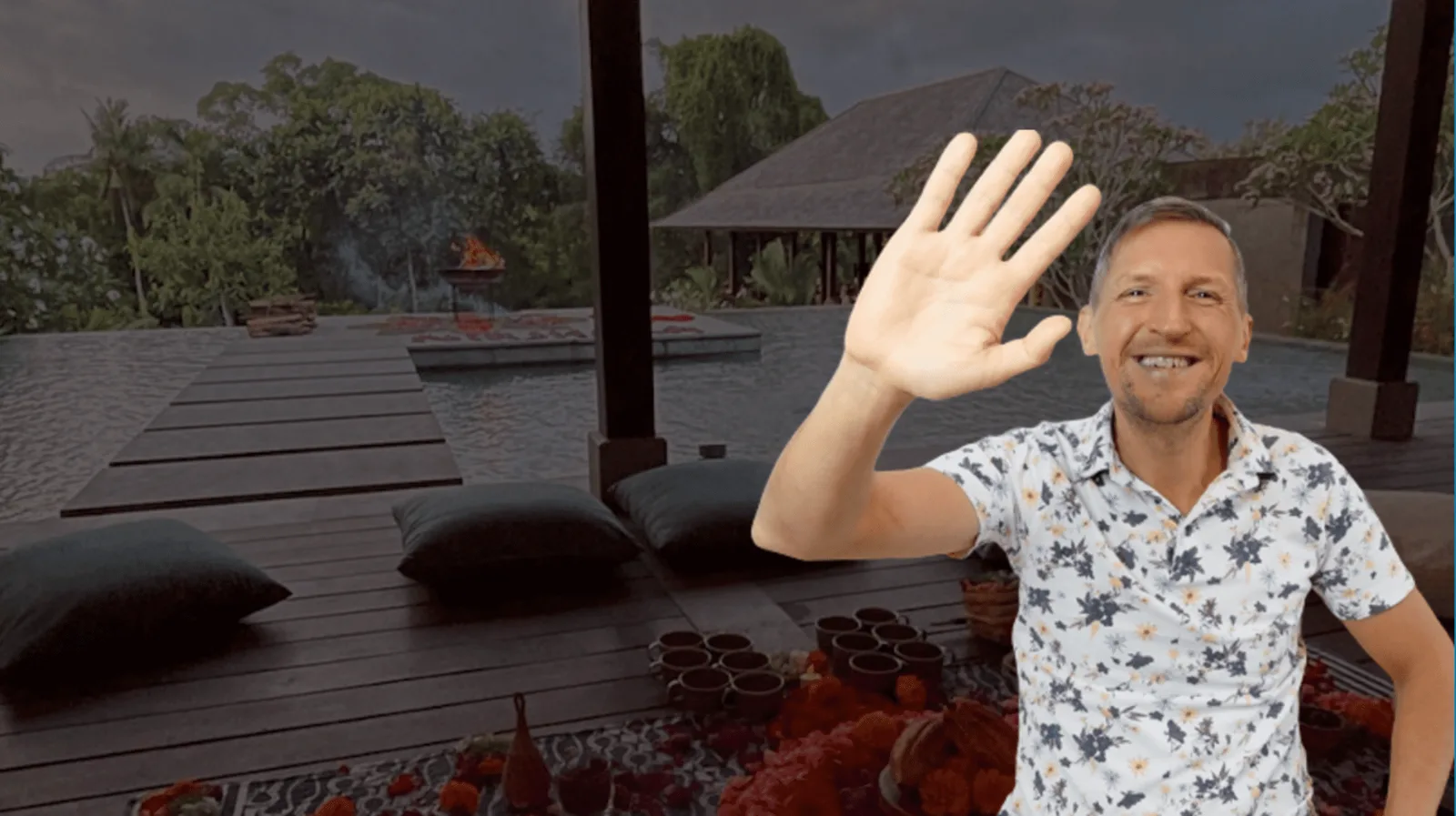 Kai Brenner winkt in tropischer Setting mit Terrasse, Wasser und Vegetation im Hintergrund