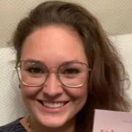 Porträt einer jungen Frau mit Brille und braunen Haaren